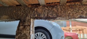 Viga de concreto deteriorada por corrosão de armadura em indústria química, evidenciando necessidade de laudo técnico estrutural