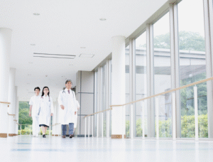 Capa do artigo sobre Projetos Complementares para Hospitais e Clínicas, apresentando uma composição técnica de um ambiente de saúde moderno com sobreposição de sistemas de engenharia (climatização, elétrica e hidráulica) e o selo de Gestão Integrada da MT Engenharia.