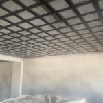 Aplicação de laminados de fibra de carbono (CFRP) para reforço estrutural de vigas e lajes de concreto armado em edificação em construção.